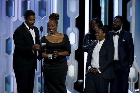 Denzel Washington (L) and his family are seen on stage after Washington won the Cecil B. Demille Award at the 73rd Golden Globe Awards in Beverly Hills,