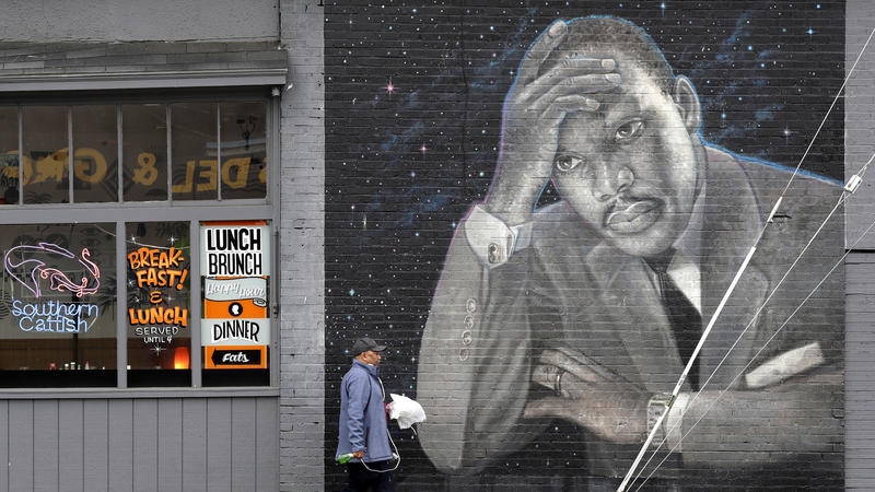 A man walks past a large mural of the Rev. Martin Luther King Jr. on the side of a diner, painted by artist James Crespinel in the 1990's and later restored, along Martin Luther King Jr. Way, Tuesday, April 3, 2018, in Seattle. (Elaine Thompson / AP)